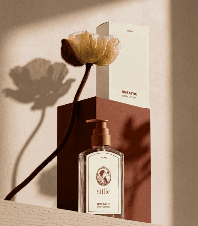 Stillé skincare bottle and packaging beside a flower