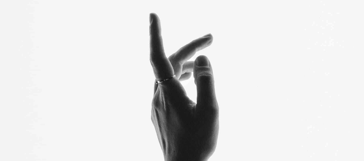 Black-and-white silhouette of an expressive hand gesture